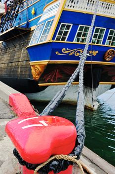 Antique sailboat mooring at red bitt in port