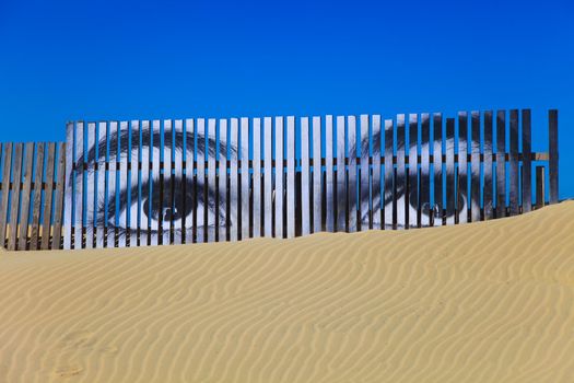 Superposed eyes on the boards of a dune of Cortadura's beach ( Cádiz )