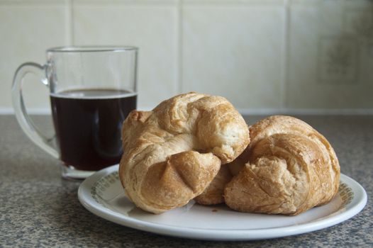 Black Coffee and two Croissants on a plate