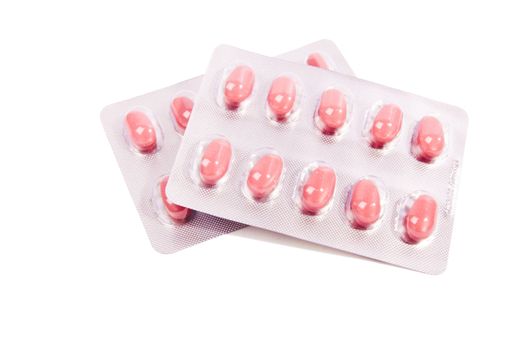 Lot pink pills over white background