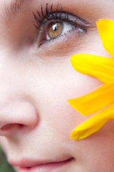 Close up of the face of a woman that is wearing a black eyed susan wildflower in her hair.  Shallow depth of field.