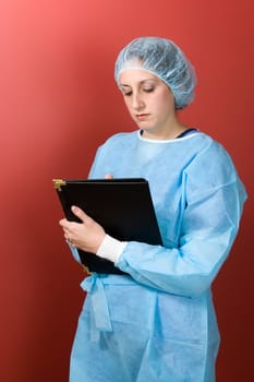 A young surgeon or doctor with a black clipboard isolated over a red background.