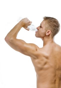 Handsome muscular male with bottle of mineral water on white background