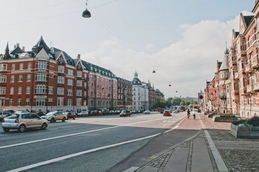 Quiet city road with old buildings and pedestrians