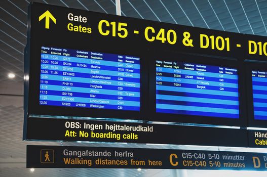 Flight information arrival departure board showing destinations, time and status in international airport