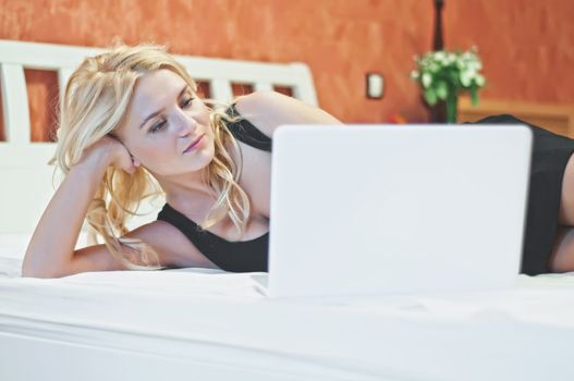 Young beautiful woman with white laptop in luxury room