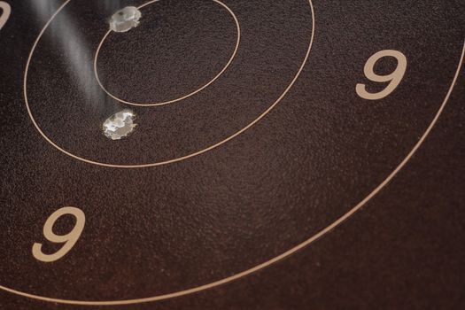 Photograph of a back-lit target sheet, showing a couple of good rounds