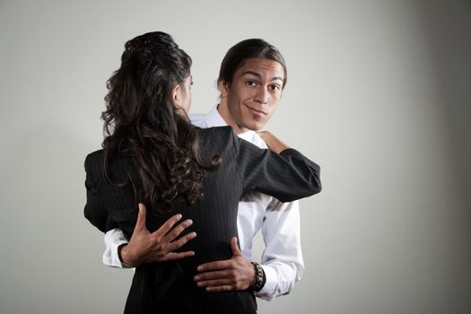 Handsome mixed race man embracing pretty Hispanic coworker