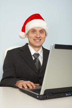 A man in a festive Christmas mood with a laptop in the Internet