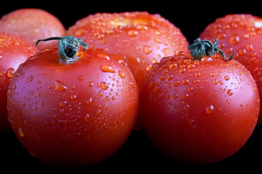 Wet whole tomatoes with isolated on black background