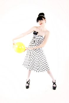 Portrait of a young beautiful brunette posing with yellow ball