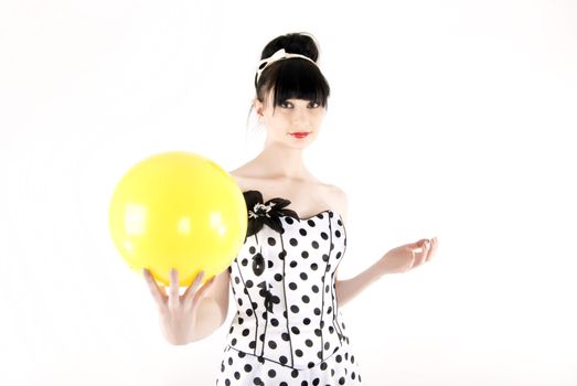 Portrait of a young beautiful brunette posing with yellow ball