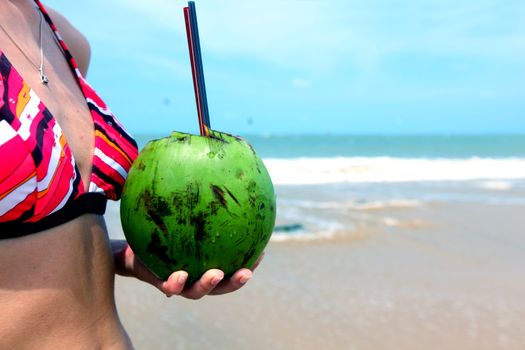 girl holding coconut cocktail in hands