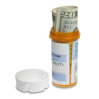 Prescription bottle with bills inside shot to illustrate the cost of medicine