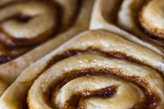 close up of cinnamon rolls or sticky buns hot out of the oven