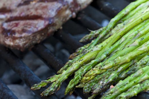 steak and asparagus on a charcoal grill short focus