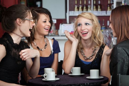 Four college freshmen chatting in a coffee shop