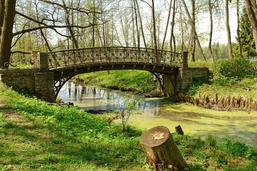 The old bridge through the thrown small river in park, Petersburg, Gatchina