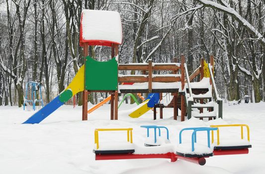 A slide in the park covered with snow in winter
