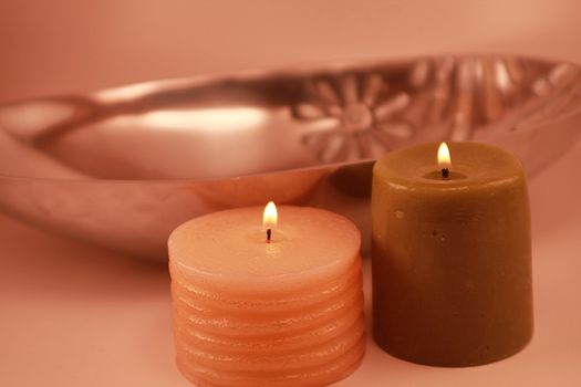 Holiday candles next to shiny dish with mother of pearl accents. Soft illumination for holidays, romance and spa.