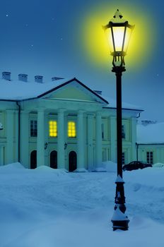 Oginski Palace in Siedlce, Poland at night covered with snow in winter with street light in the foreground