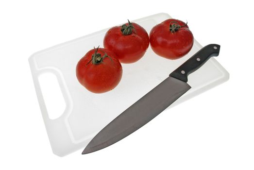 Cutting board with a knife and tomato isolated on a white background.
