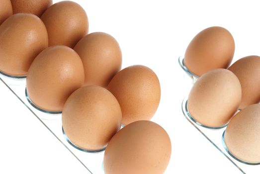 Brown eggs on a acrylic transparent stand isolated on white background.