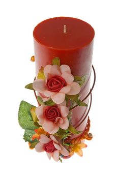 Large red candle with the flower decoration isolated on white background.