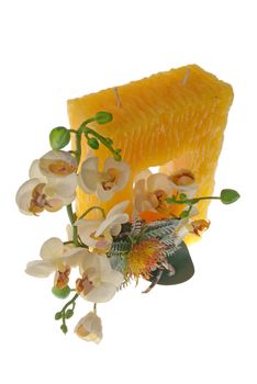 Large yellow candle with the flower decoration isolated on white background.