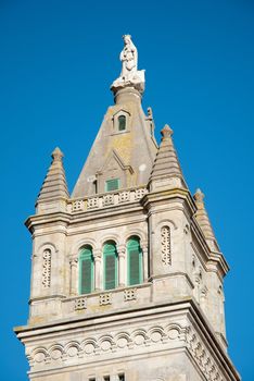 Portuguese church tower detail view agains blue clear sky.