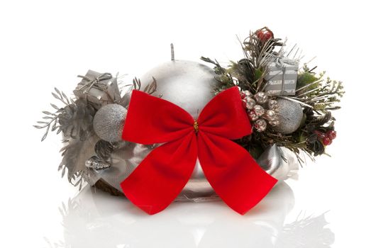 Silver candle with red lace and christmas decorations on white background.