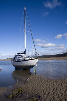 Yacht at anchor in Red Wharf Bay, Anglesey at low tide