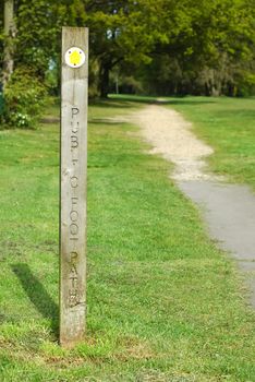 public foot path direction sign into woodland