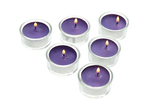 Purple candles in glass isolated on white background.