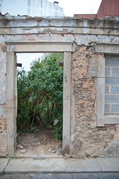 Old house facade with broken door and windows.