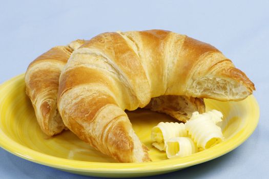 Croissants with butter over light blue background
