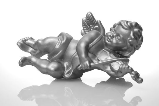 Angel plastic statue of an silver angel playing violin with reflection on white background.