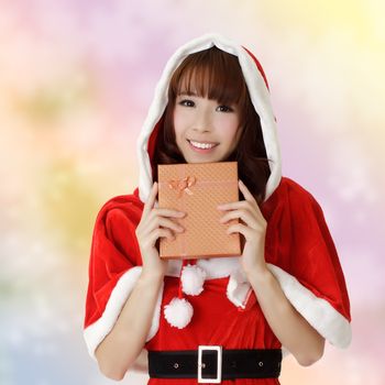 Happy Christmas woman holding gift box over colorful background.