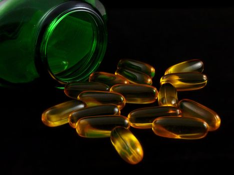 Fish oil suppliment, transparent capsules towards black background