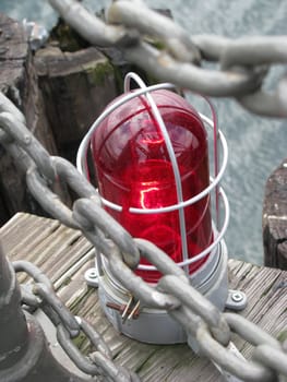 A red warning light on the end of a pier.