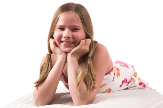 Pretty blond girl lying on a couch and leaning on her hands