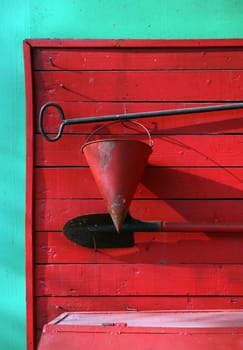 bucket, a shovel, a breakage against an old wooden red shed