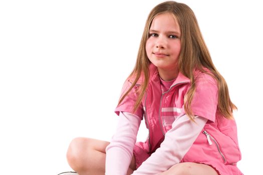 Pretty smiling ten year old girl sitting crosslegged on the couch