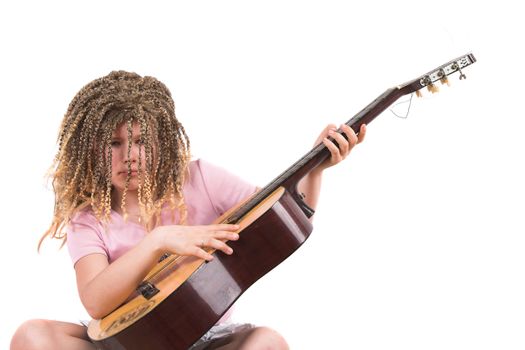 Ten year old girl with rasta wig seriously working on her guitar