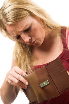 Pretty blond woman looking into her wallet with a worried face