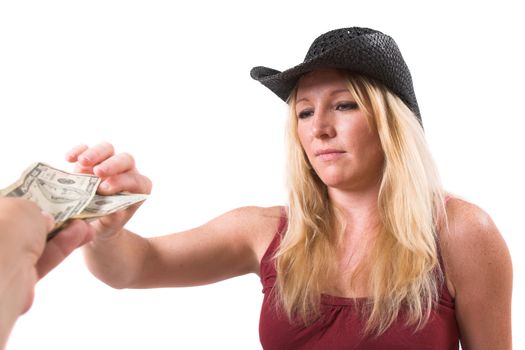 Pretty blond woman looking annoyed while grabbing the dollars that are hold out to her