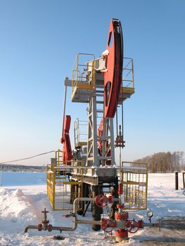 Oil pump jack in work. Oil industry in West Siberia. Siberian frost in sunny day.
