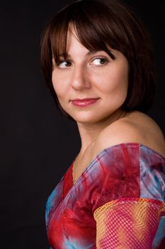 The woman in a bright dress on a black background