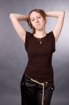 The young girl in brown shirt-blouse on a grey background