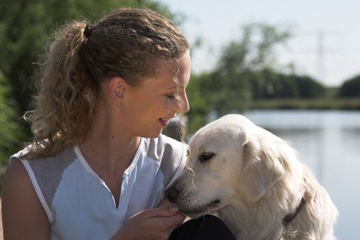 Beautiful blond woman out by the waterside with her dog